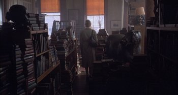 Movie still from “Unfaithful” (2002), directed by Adrian Lyne – A woman standing in a room filled with stacks of books; Wide shot, High angle