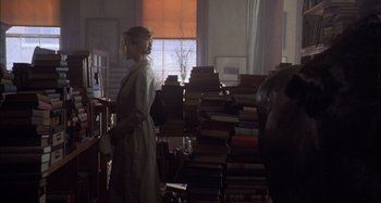 Movie still from “Unfaithful” (2002), directed by Adrian Lyne – A woman standing in front of a large pile of books; Medium shot, Over the shoulder angle