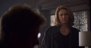 Movie still from “Unfaithful” (2002), directed by Adrian Lyne – A woman standing in front of a mirror in a dark room; Close Up shot, Over the shoulder angle
