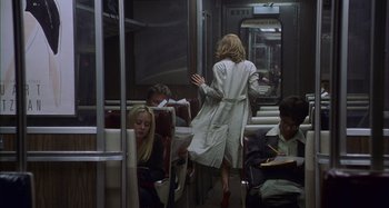 Movie still from “Unfaithful” (2002), directed by Adrian Lyne – A woman in a trench coat walking on a subway train; Wide shot, Over the shoulder angle
