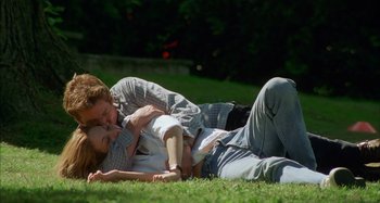 Movie still from “Unfaithful” (2002), directed by Adrian Lyne – A man and a woman laying in the grass; Medium shot, High angle