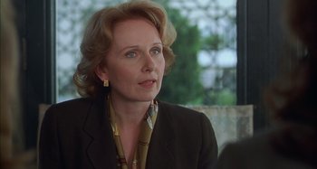 Movie still from “Unfaithful” (2002), directed by Adrian Lyne – An older woman with blonde hair and wearing a black suit; Close Up shot, Over the shoulder angle