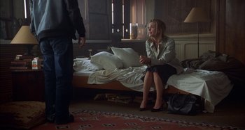 Movie still from “Unfaithful” (2002), directed by Adrian Lyne – A woman sitting on top of a bed next to a man; Wide shot, Over the shoulder angle