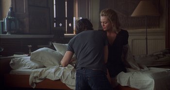 Movie still from “Unfaithful” (2002), directed by Adrian Lyne – A man and a woman are sitting on a bed together; Medium shot, Over the shoulder angle