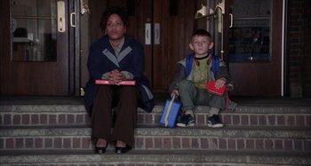 Movie still from “Unfaithful” (2002), directed by Adrian Lyne – A woman and a boy sitting on the steps of a building; Wide shot, Low angle