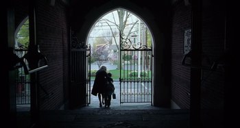 Movie still from “Unfaithful” (2002), directed by Adrian Lyne – Two people standing in front of an arched gate; Extreme Wide shot, Low angle
