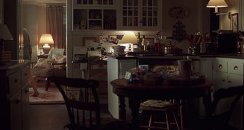 Movie still from “Unfaithful” (2002), directed by Adrian Lyne – A room with a table and chairs and a lamp; Wide shot, High angle