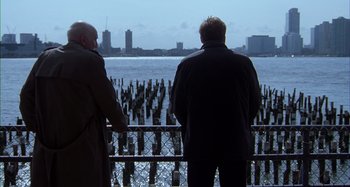 Movie still from “Unfaithful” (2002), directed by Adrian Lyne – Two men looking out over a body of water; Wide shot, Low angle