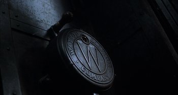 Movie still from “Unfaithful” (2002), directed by Adrian Lyne – An old clock with the company logo on it in a dark room; Extreme Close Up shot, Overhead angle
