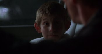 Movie still from “Unfaithful” (2002), directed by Adrian Lyne – A young boy is looking at the camera; Close Up shot, Over the shoulder angle