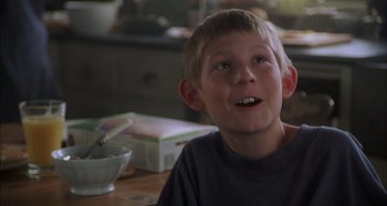 Movie still from “Unfaithful” (2002), directed by Adrian Lyne – A young boy sitting at a table with a bowl; Close Up shot, Low angle
