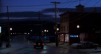 Movie still from “Unfaithful” (2002), directed by Adrian Lyne – A car is parked on the side of the road at night; Extreme Wide shot, High angle