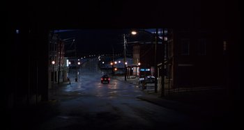 Movie still from “Unfaithful” (2002), directed by Adrian Lyne – A car driving down a street at night; Extreme Wide shot, High angle