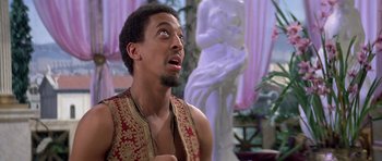 Movie still from “History of the World: Part I” (1981), directed by Mel Brooks – A man with a surprised look on his face in front of a statue; Close Up shot, Low angle