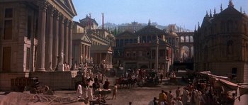 Movie still from “History of the World: Part I” (1981), directed by Mel Brooks – People are gathered in a courtyard in a city setting; Extreme Wide shot, High angle