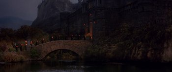 Movie still from “History of the World: Part I” (1981), directed by Mel Brooks – A castle with a bridge over a body of water near a forest; Extreme Wide shot, High angle