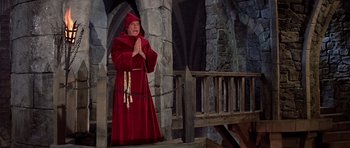 Movie still from “History of the World: Part I” (1981), directed by Mel Brooks – A man dressed as a monk standing in front of a stone wall; Wide shot, High angle