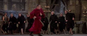 Movie still from “History of the World: Part I” (1981), directed by Mel Brooks – A group of people dressed in black walking in a line; Wide shot, High angle