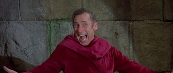 Movie still from “History of the World: Part I” (1981), directed by Mel Brooks – A man wearing a red robe and a red hood; Close Up shot, Low angle