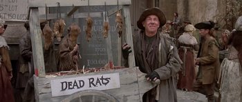 Movie still from “History of the World: Part I” (1981), directed by Mel Brooks – A man in a hat standing in front of dead rats; Medium shot, Low angle