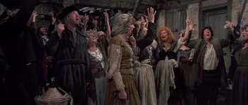 Movie still from “History of the World: Part I” (1981), directed by Mel Brooks – A group of people standing around each other in a room; Wide shot, High angle