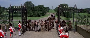 Movie still from “History of the World: Part I” (1981), directed by Mel Brooks – A group of people standing on top of a dirt road; Extreme Wide shot, High angle