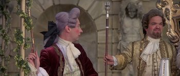 Movie still from “History of the World: Part I” (1981), directed by Mel Brooks – A man in a wig holding a cane and looking at another man in a suit; Medium shot, Over the shoulder angle