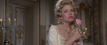 Movie still from “History of the World: Part I” (1981), directed by Mel Brooks – A woman in a white dress with a flower in her hair; Close Up shot, Over the shoulder angle