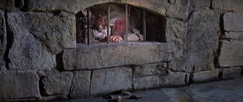 Movie still from “History of the World: Part I” (1981), directed by Mel Brooks – An old man is looking out of a jail cell; Medium shot, High angle