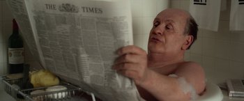 Movie still from “Hitchcock” (2012), directed by Sacha Gervasi – A man reading a newspaper in a bathroom; Close Up shot, Low angle