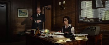 Movie still from “Hitchcock” (2012), directed by Sacha Gervasi – A man and a woman sitting at a desk; Medium shot, Over the shoulder angle