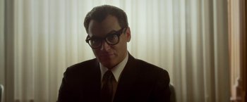 Movie still from “Hitchcock” (2012), directed by Sacha Gervasi – A man in a suit and glasses looking at the camera; Close Up shot, Low angle