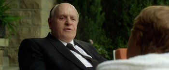 Movie still from “Hitchcock” (2012), directed by Sacha Gervasi – An older man wearing a suit and tie; Close Up shot, Over the shoulder angle