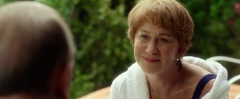 Movie still from “Hitchcock” (2012), directed by Sacha Gervasi – An older woman wearing a white robe and smiling; Close Up shot, Over the shoulder angle