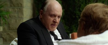 Movie still from “Hitchcock” (2012), directed by Sacha Gervasi – An older man wearing a suit and tie; Close Up shot, Over the shoulder angle