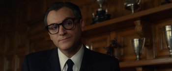 Movie still from “Hitchcock” (2012), directed by Sacha Gervasi – A person wearing a suit and glasses; Close Up shot, Over the shoulder angle