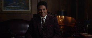 Movie still from “Hitchcock” (2012), directed by Sacha Gervasi – A man in a suit and tie sitting in a chair; Medium shot, High angle