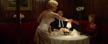 Movie still from “Hitchcock” (2012), directed by Sacha Gervasi – A woman in a white dress standing in front of a man in a suit; Medium shot, Over the shoulder angle