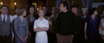 Movie still from “Hitchcock” (2012), directed by Sacha Gervasi – A group of men and women standing around a woman; Medium shot, Low angle