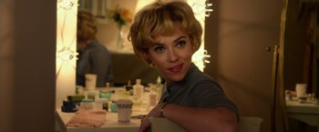 Movie still from “Hitchcock” (2012), directed by Sacha Gervasi – A woman sitting in front of a bunch of candles; Close Up shot, Over the shoulder angle
