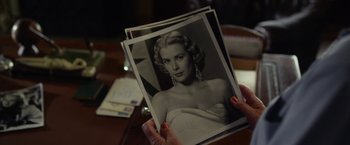 Movie still from “Hitchcock” (2012), directed by Sacha Gervasi – A person holding a picture of a woman in black and white; Close Up shot, Over the shoulder angle