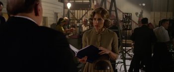 Movie still from “Hitchcock” (2012), directed by Sacha Gervasi – A woman is holding a book while standing in a room; Medium shot, Over the shoulder angle