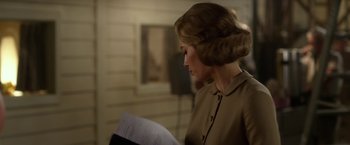 Movie still from “Hitchcock” (2012), directed by Sacha Gervasi – A woman in a brown dress is reading; Close Up shot, Over the shoulder angle