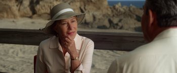 Movie still from “Hitchcock” (2012), directed by Sacha Gervasi – An older woman sitting on a bench wearing a hat; Close Up shot, Over the shoulder angle