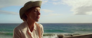 Movie still from “Hitchcock” (2012), directed by Sacha Gervasi – A woman wearing a straw hat near the ocean; Close Up shot, Over the shoulder angle