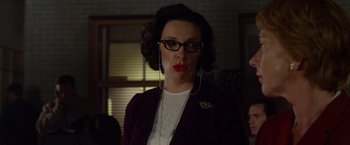 Movie still from “Hitchcock” (2012), directed by Sacha Gervasi – A woman wearing glasses standing in front of a window; Close Up shot, Over the shoulder angle