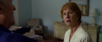 Movie still from “Hitchcock” (2012), directed by Sacha Gervasi – An older woman in a living room looking sad; Close Up shot, Over the shoulder angle