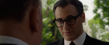 Movie still from “Hitchcock” (2012), directed by Sacha Gervasi – A person wearing a suit and glasses; Close Up shot, Over the shoulder angle