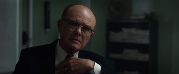 Movie still from “Hitchcock” (2012), directed by Sacha Gervasi – An older man in a suit and tie looking to his left; Close Up shot, Over the shoulder angle