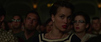 Movie still from “Hitchcock” (2012), directed by Sacha Gervasi – A person with a crowd in the background; Close Up shot, Over the shoulder angle